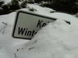 Hinweisschild „Kein Winterdienst“, versunken im Schnee